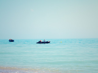 Мinimalist silhouette of fishing boats and fishermen in the calm waters of the sea in the second half of the day. Minimal style with colorful clouds and sky background.