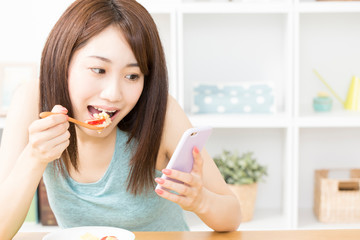 Sticker - 朝食を食べながらスマホを見る女性