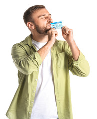 Wall Mural - Happy young man with driving license on white background