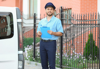 Poster - Handsome young postman near car outdoors