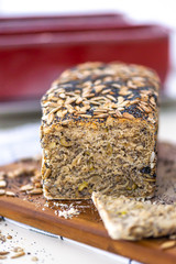 Whole grain bread on kitchen wood plate with. Fresh bread on table close-up. H