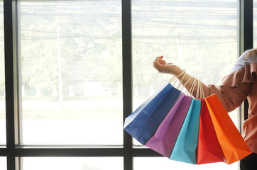 Young woman holding sale shopping bags. consumerism lifestyle concept in the shopping mall