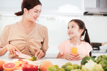 Wall Mural - happy Mother and child daughter  preparing the vegetables and fruit in kitchen