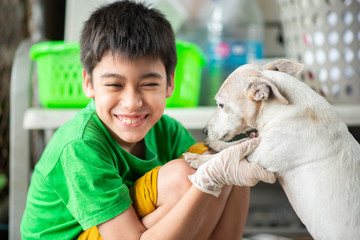 Little teen boy hugging and kissing old dog jack russel with love