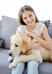 Canvas Print - Smiling teenage girl with adorable dog in light room