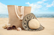 Different stylish beach objects, coral and seashell on sand near sea