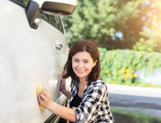 Wall Mural - Happy woman with rag next to white shining car on sunny day