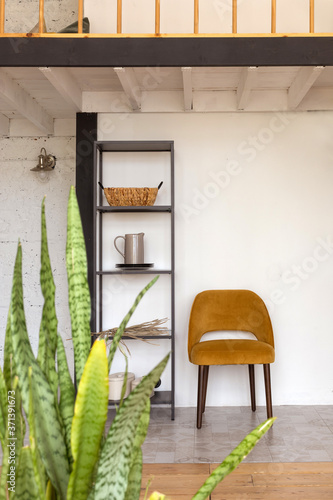 Fotomural Shelves with decorations and comfortable chair placed under mezzanine in stylish