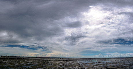 Wall Mural - landscape of mud beach, sea, and sky. panorama view of beach at tide and skyline. beautiful cloudsca