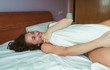 © Martley - Portrait of a smiling attractive woman enjoying morning lying down on bed with closed eyes.