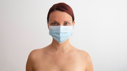 Caucasian woman with a medical mask on his face on a white background.