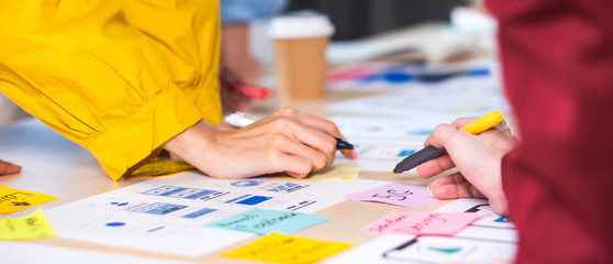 close up hand ux developer and ui designer brainstorming about mobile app interface wireframe design