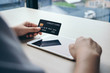 Hands holding plastic credit card and using tablet mobile. Online shopping concept.