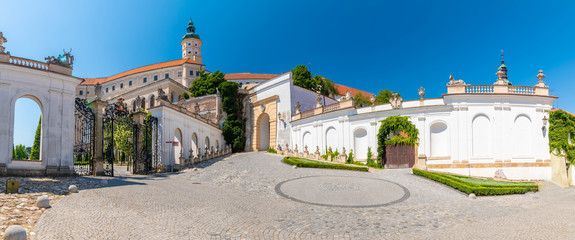 Wall Mural - The Mikulov castle, Czech republic. Famous medieval castle on top of hill. Beautiful ornament garden with flowers, trees and green grass. Summer weather and blue sky. Beautiful wine region near Palava