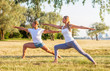 © Acronym - Fit man and beautiful woman practicing yoga outdoor on the grass. Stretching exercise in the sunset. Sport, fitness, health care and lifestyle concepts.