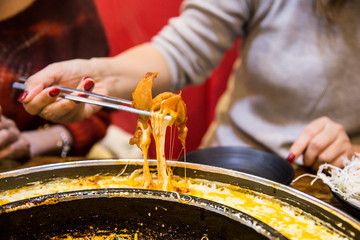 Poster - 韓国料理のチーズタッカルビを食べる女性