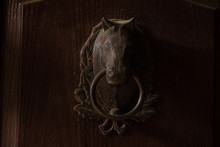 Horse With A Ring On A Brown Door In A Stable Close-up As A Handle