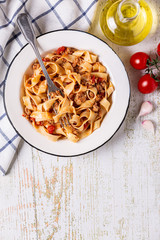 Wall Mural - Traditional italian pasta bolognese on a white plate on a wooden background