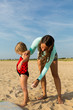 © Tetra Images - Mother spraying sunscreen on daughter at beach