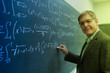 © Tetra Images - Caucasian teacher writing on chalkboard