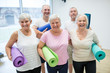 © Westend61 - Group of happy seniors holding mats for yoga class