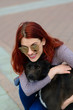© Ivan Zelenin - Beautiful happy young woman with cute black dog have fun on street.