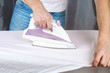 © detry26 - A man strokes linen with an electric iron on an ironing board. Household.