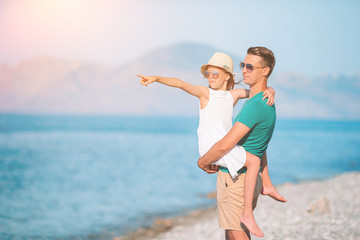 Little girl and happy dad having fun during beach vacation