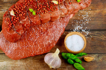 Wall Mural - Uncooked beef fillet with herbs and spices on wooden board.