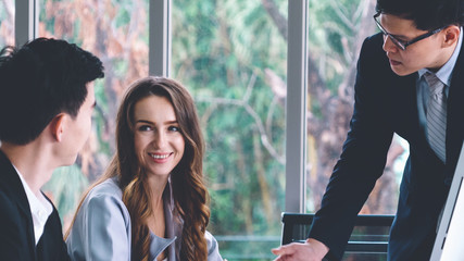 Wall Mural - Smart businessman and businesswoman talking discussion in group meeting at office table in a modern office interior. Business collaboration strategic planning and brainstorming of coworkers.