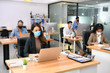 © amenic181 - Asian office workers wearing face masks working in new normal office and doing social distancing during corona virus covid-19 pandemic