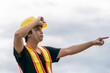 © marchsirawit - Engineer wearing yellow helmet and his hand is pointing the job, controlling the construction.