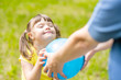 © Ermolaev Alexandr - Little girl with syndrome down and her mother play with a ball in a summer park