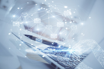 Desktop computer background in office and flying envelops hologram drawing. Double exposure. Electronic mail concept.