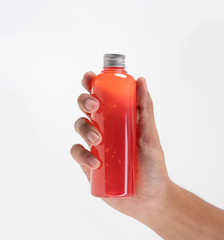 Sticker - hand holding fruit juice on a plastic bottle product mockup