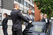 Bodyguards Protecting Businessman Opening Car Door