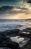 Fototapeta Morze - Rocky seashore with windy waves at sunset. Xilofagou Larnaca Cyprus