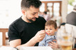 © FotoAndalucia - Bearded father feeding little baby son in restaurant