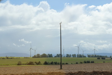 wind turbines on a field with stormy sky