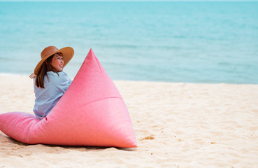 Summer vocation concept : Young woman  wearing stylish blue dress and straw hat with blue sky background on the beach.Cover banner concept.