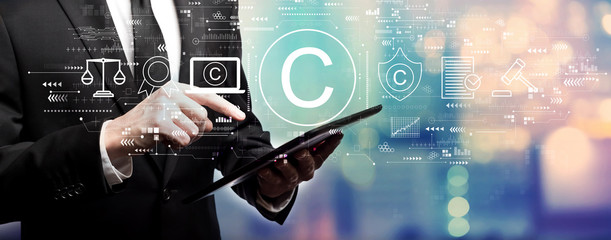 Wall Mural - copyright concept with businessman using his tablet computer