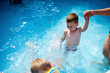 © Dejan - Little boys and his mother having fun in swimming pool at back yard