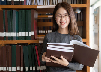 Back to school education knowledge college university concept, Beautiful female college student holding her books smiling happily standing in library, Learning and education concept
