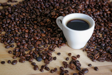 Wall Mural -  A cup of black coffee with coffee grains, natural light on wooden table