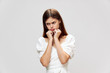 © SHOTPRIME STUDIO - Sad woman looks away from her hands near her face displeased white t-shirt