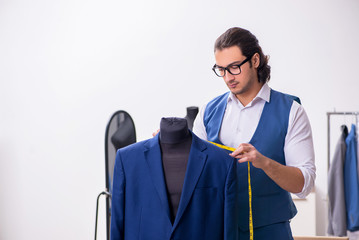 Young male tailor working at workshop