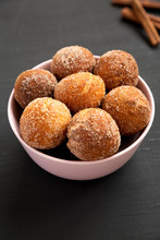 Homemade Fried Donut Holes In A Pink Bowl On A Black Surface, Low Angle View.