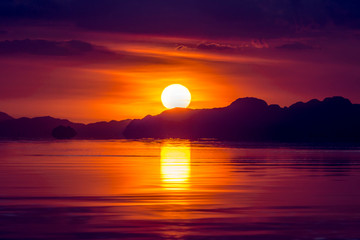 Poster - Sunset sky with cloud and silhouette mountain at the lake.