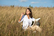 © Dmitry - Young European student woman with a book in a field in autumn or summer