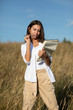 © Dmitry - Young European student woman with a book in a field in autumn or summer